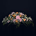 Casket spray with seasonal flowers and natural foliage