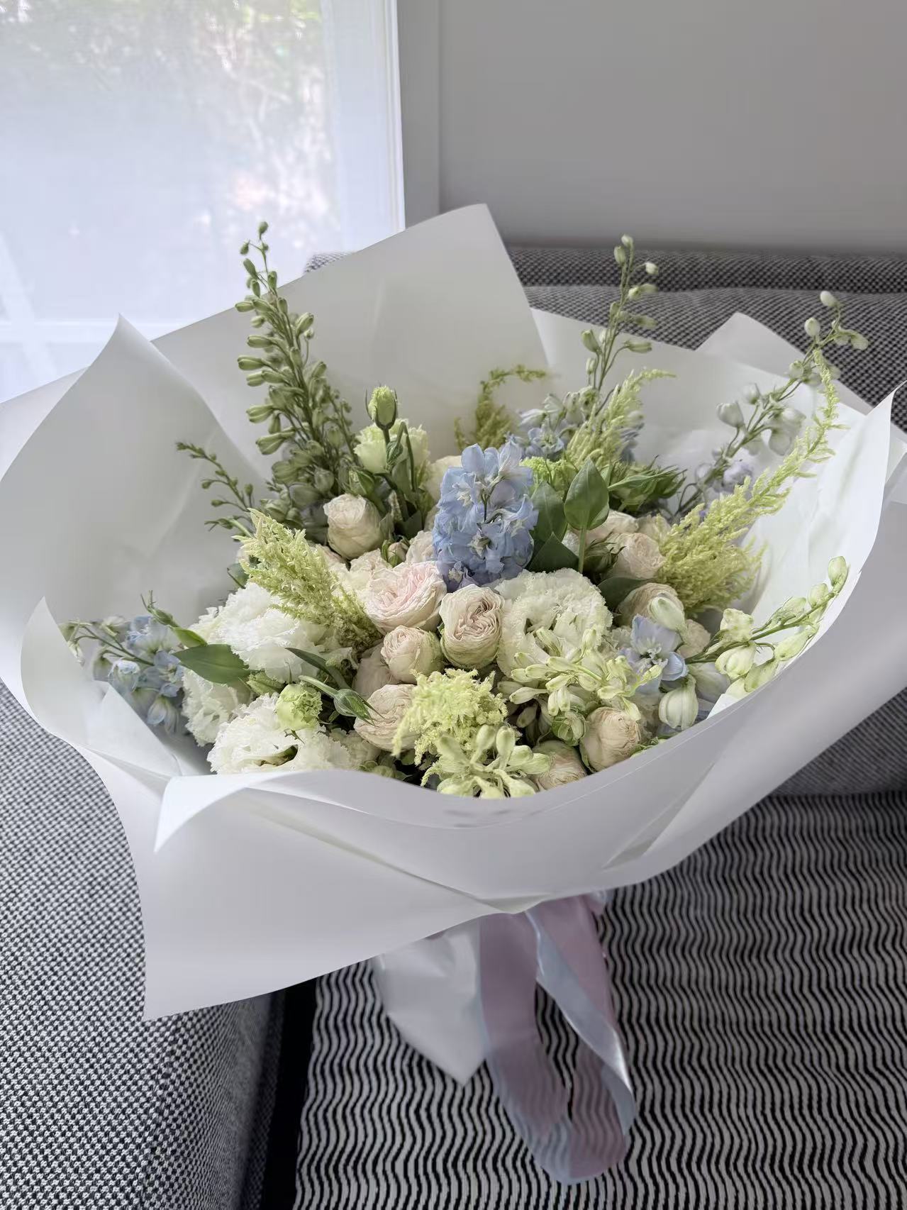 Pink spray rose, blue delphinium and lisianthus bouquet