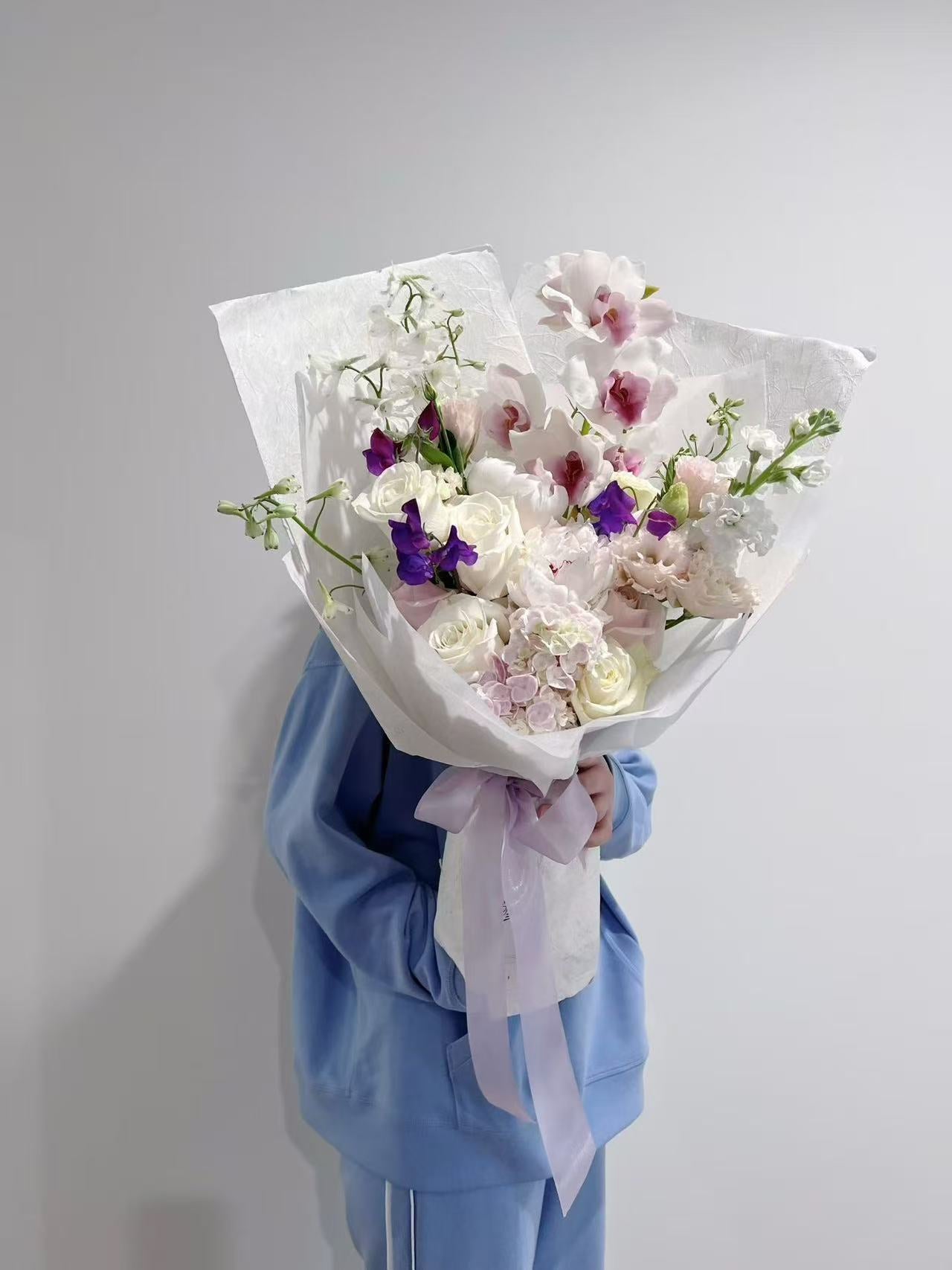 White rose bouquet with plum flowers and cymbidium orchids