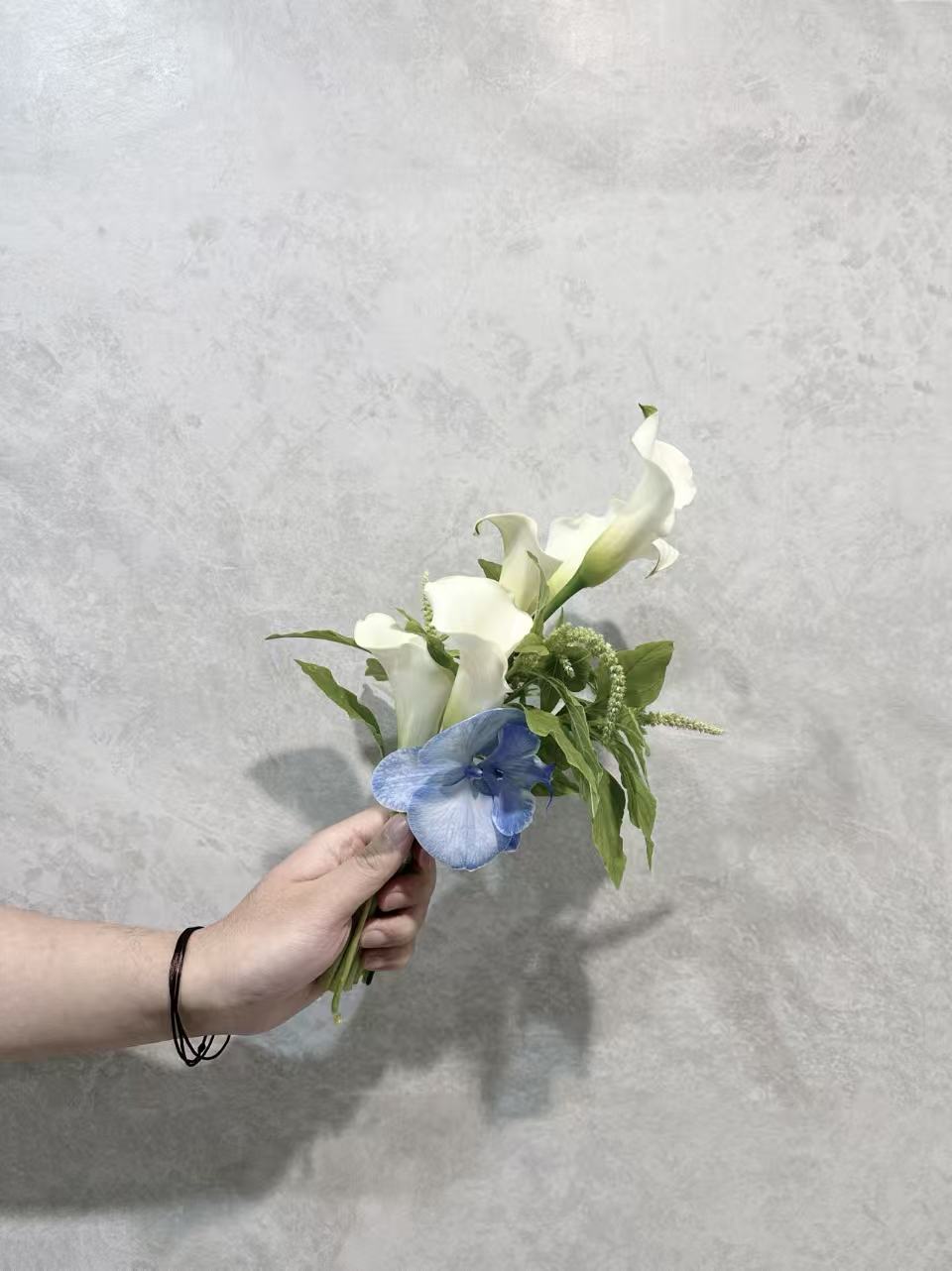 White calla lily bouquet with soft blue accents
