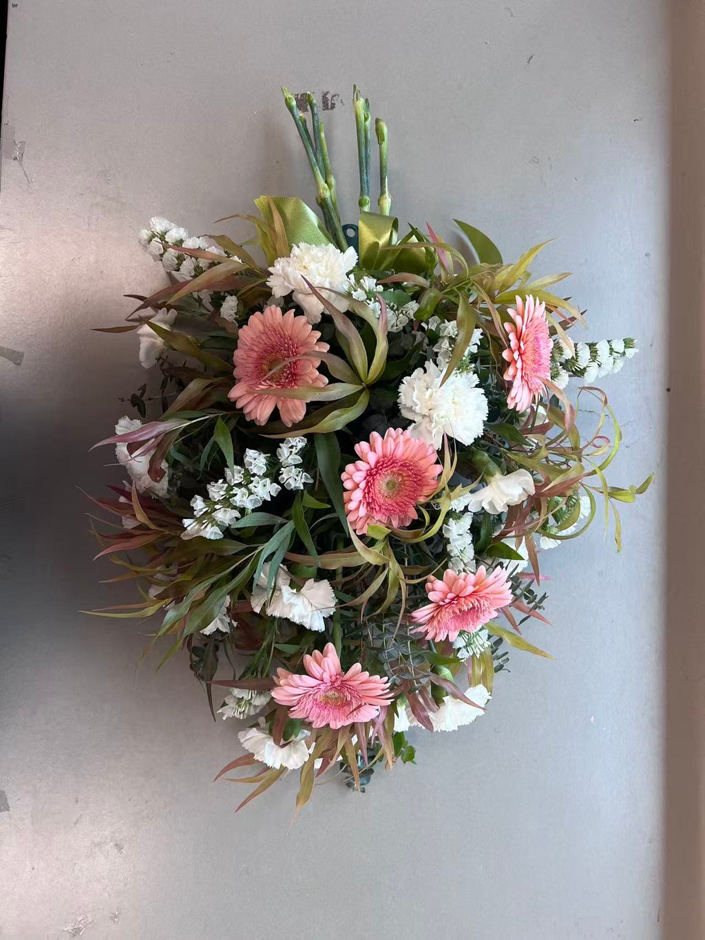 Teardrop-shaped funeral flower tribute in pink, orange, purple and white